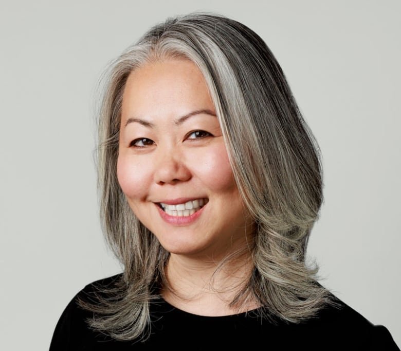 A woman wearing a black shirt is smiling at the camera.