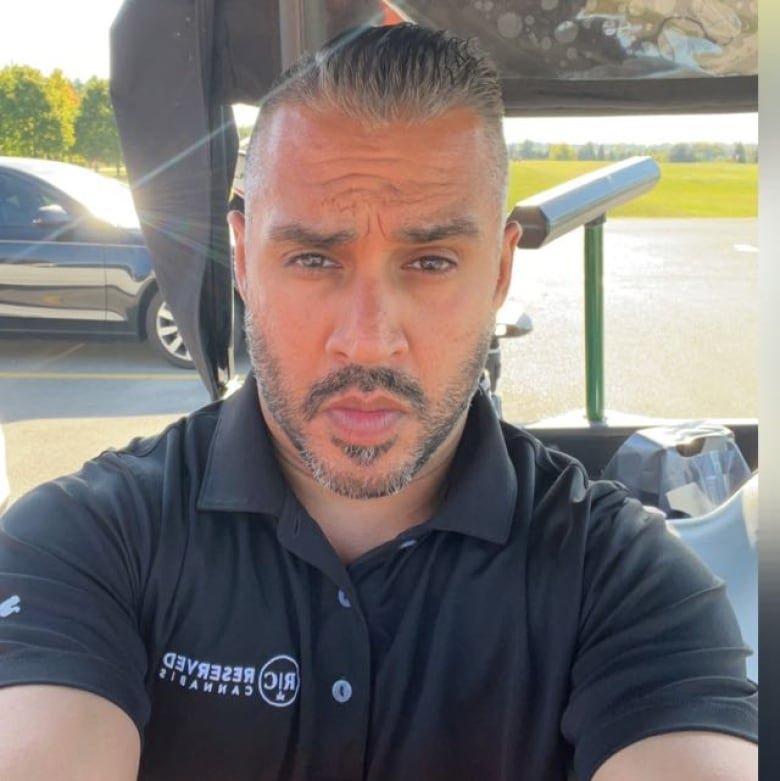 A selfie of a man with a short beard wearing a black polo shirt.