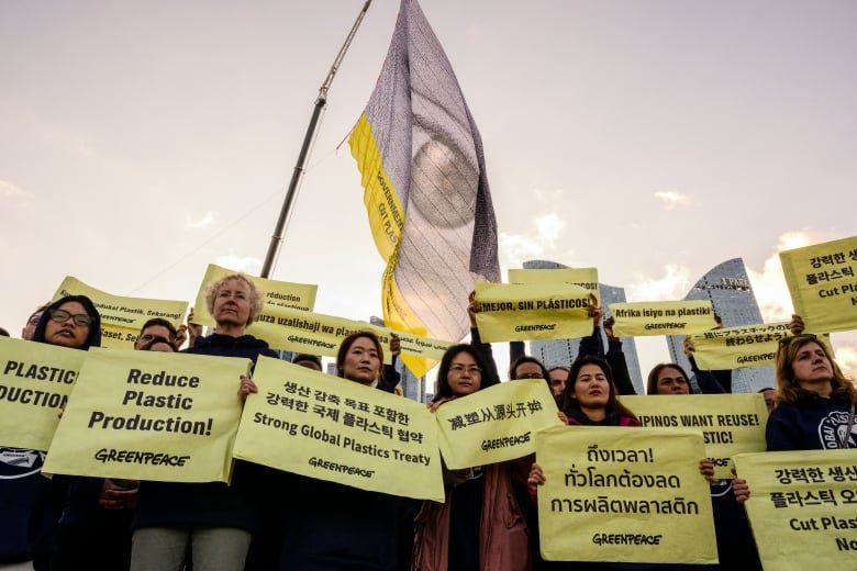 Greenpeace activists hold placards in Busan, South Korea outside a pollution treaty talks on November 25, 2024.