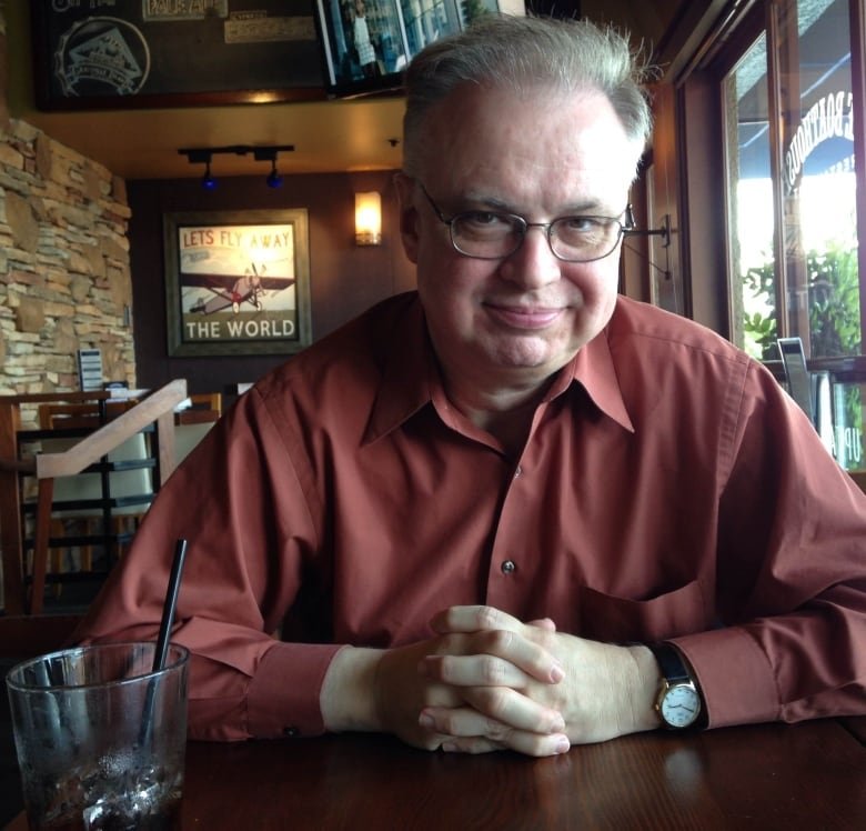 Marc Mentzer pictured sitting a table with a drink beside him.