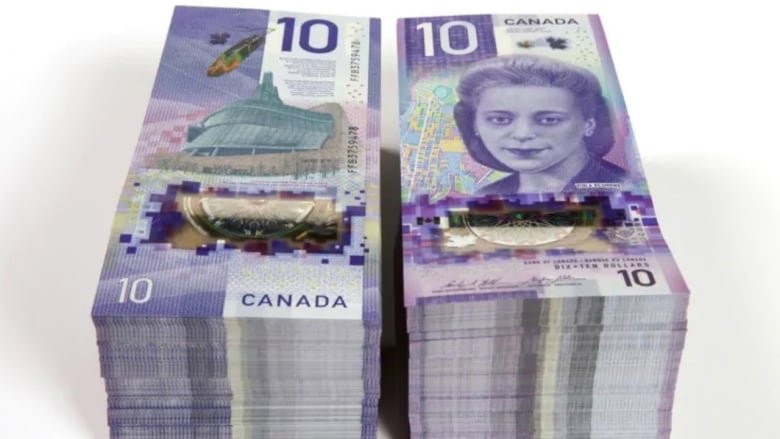 Two stacks of purple bank notes with the number 10 in large digits and an image of a young Black woman.