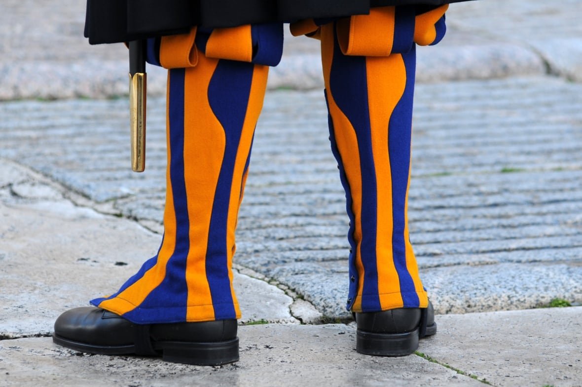 A person's legs wearing striped yellow and blue coverings.