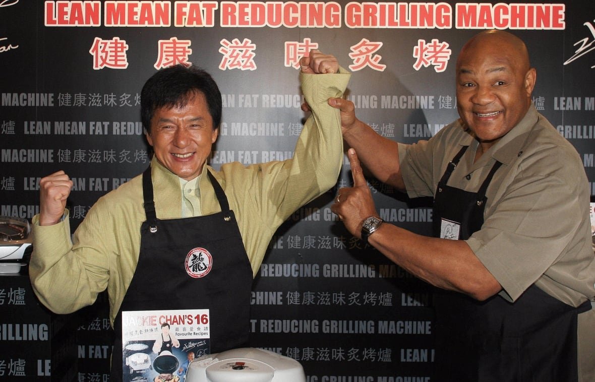 73849200 An African American and an Asian hold each other's arms up while wearing an apron.