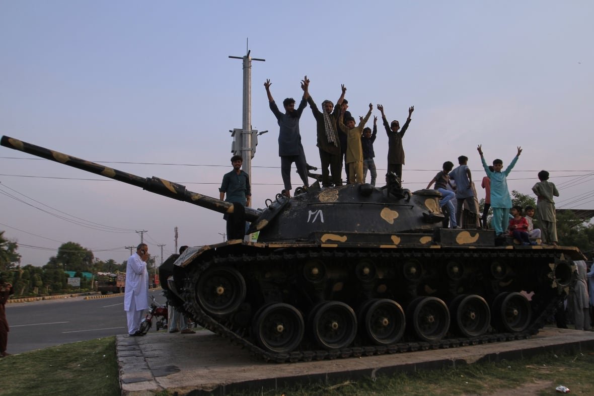 aptopix-pakistan-india People cheer and celebrate atop a tank.