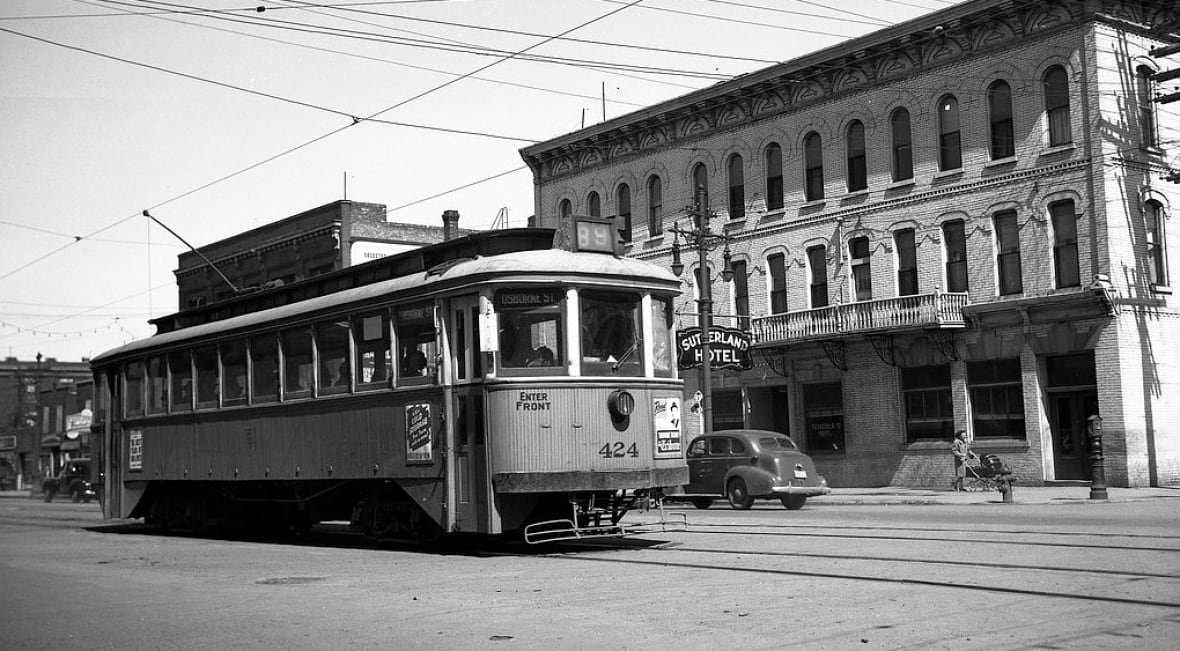 streetcar-passes-the-sutherland-hotel Black and white photograph shows a streetcar passing a building.