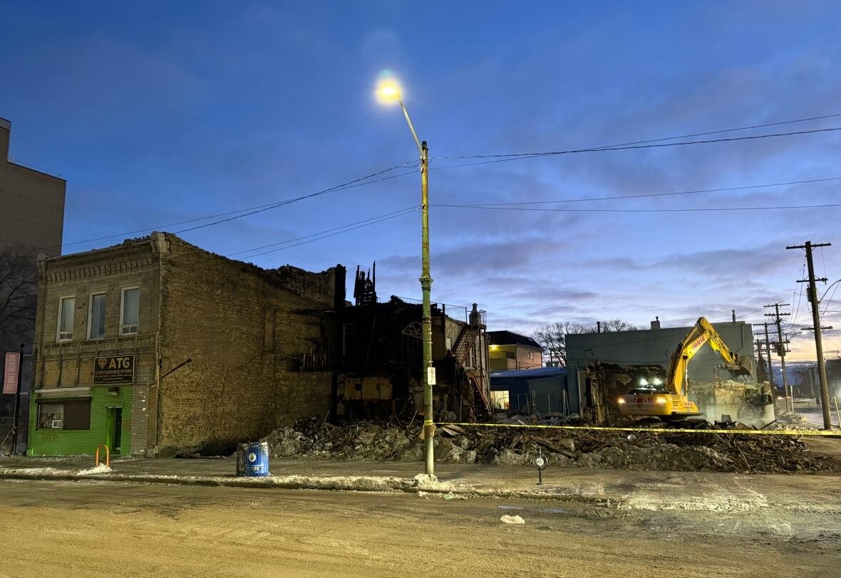 sutherland-hotel-demolished A backhoe stands on a pile of rubble from a demolished building.