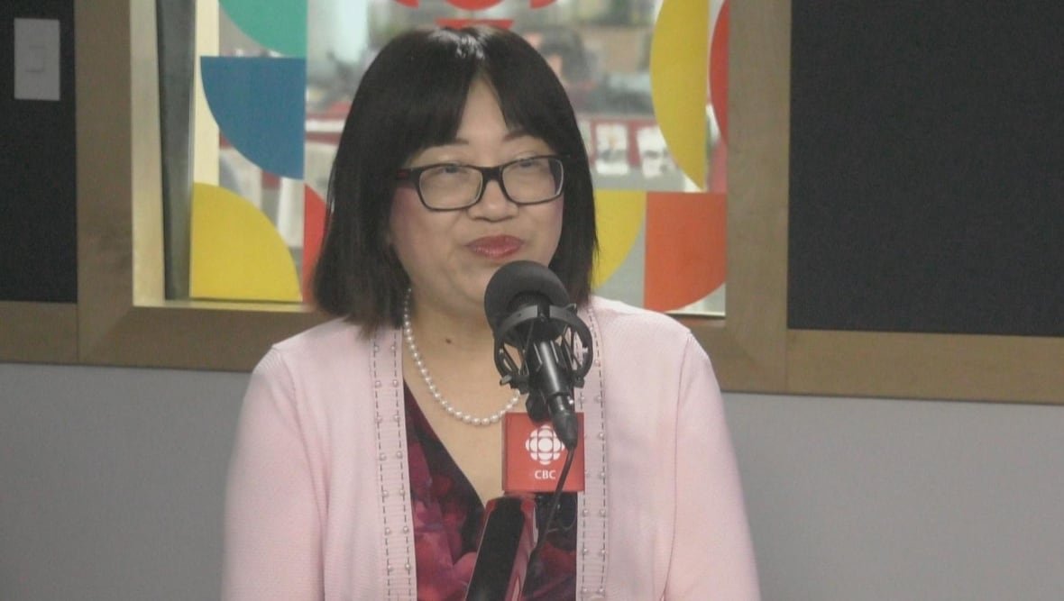 linda-qin An East Asian woman smiles in a radio studio.