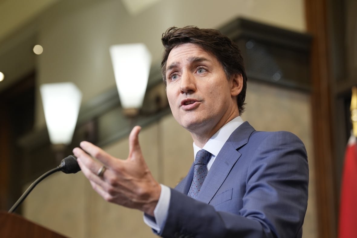 A man gestures while standing at a podium