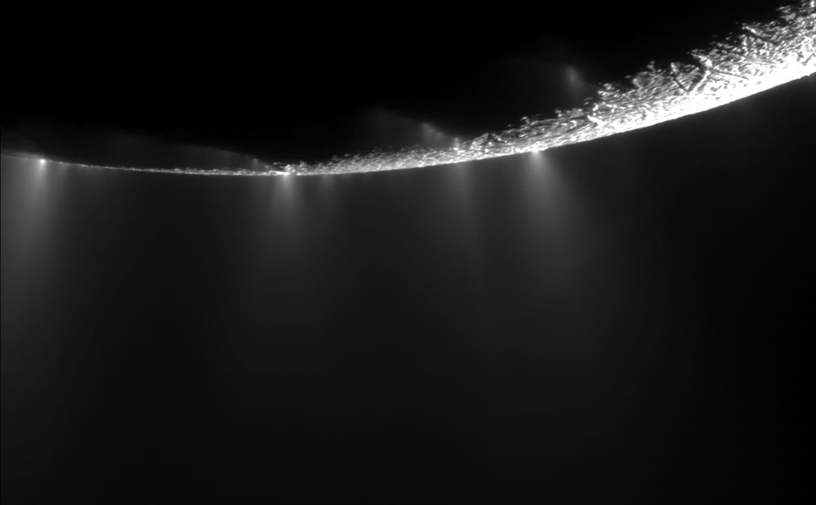 enceladus-1 A crescent of a moon shows plumes emerging.