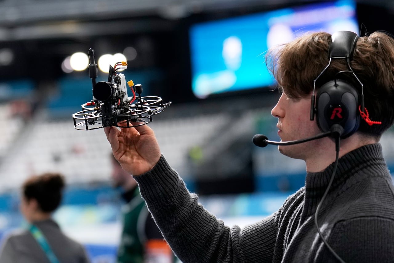 A person holds a drone close to their face.