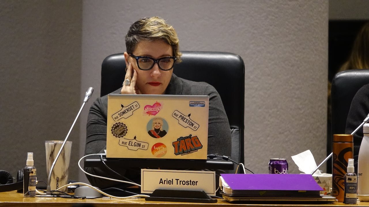Ariel Troster looks at a laptop decorated by stickers.