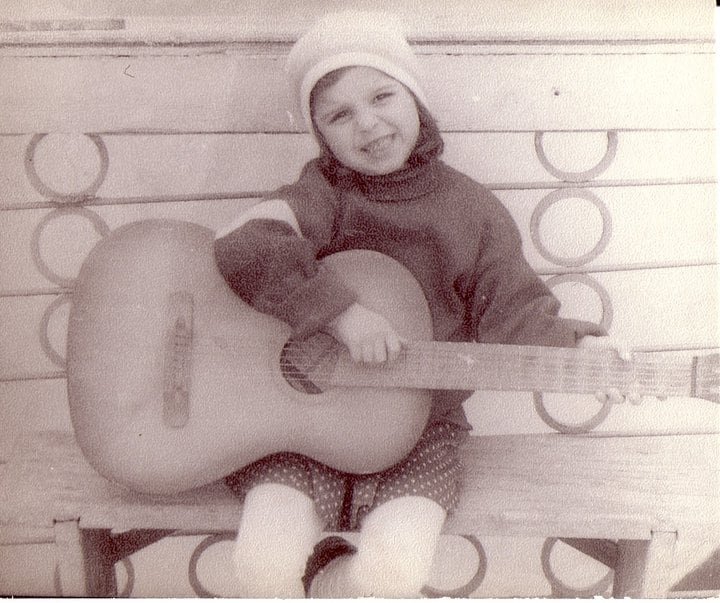 default-464 A child holding a guitar in a black and white photo.