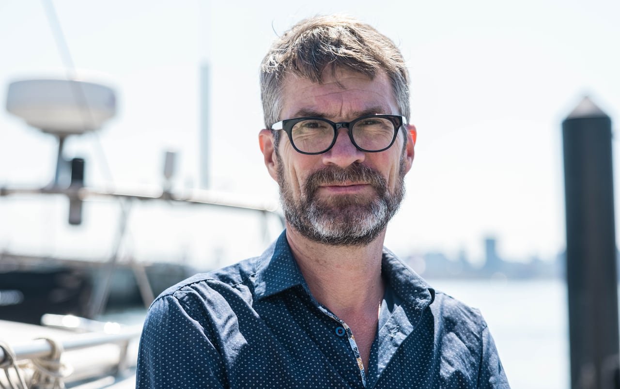 A man posing for a photo outside.