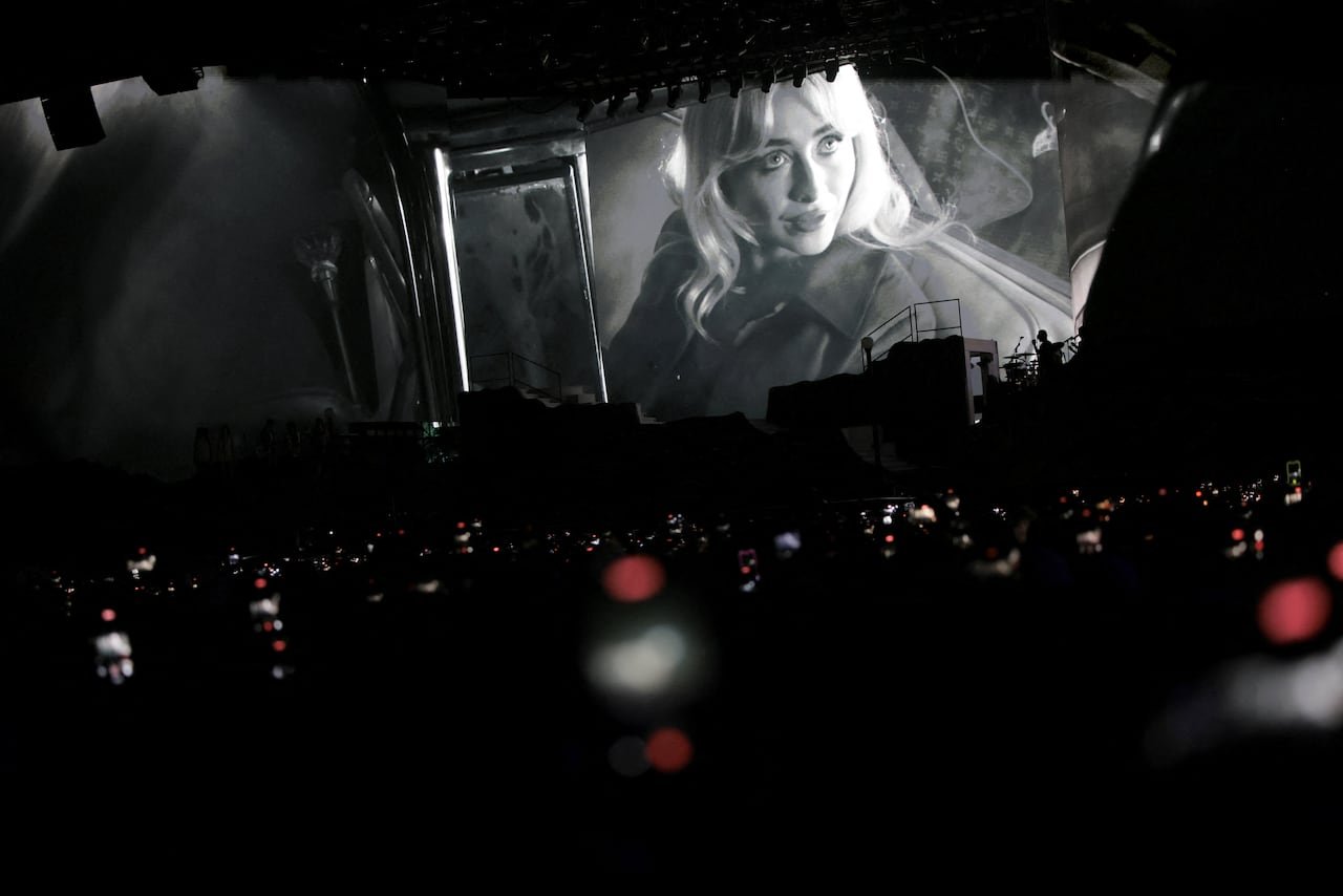 A female artist performing on stage at a music festival.