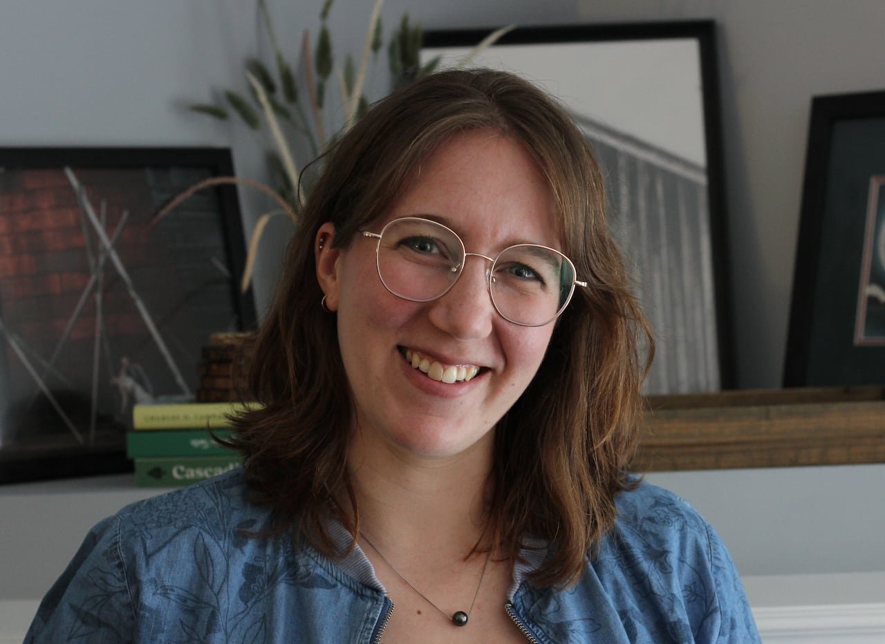 A brunette white woman smiles at the camera.