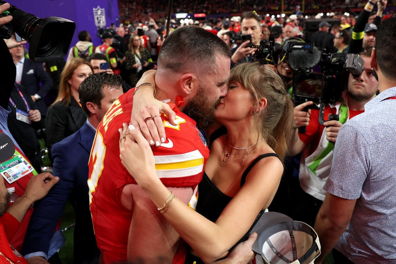 default-385 football player embracing woman in black tank top with ponytail amidst a crowd on the field