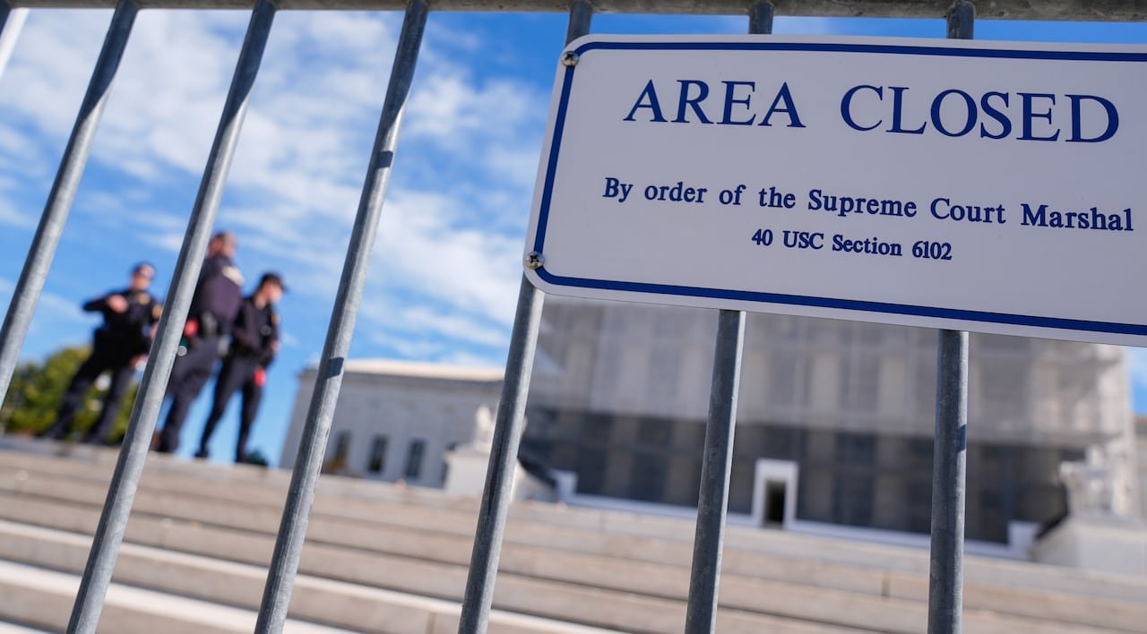 default-860 The Supreme Court and some Capitol Police officers are seen behind a sign posted on a gate that reads, 'Area Closed.'