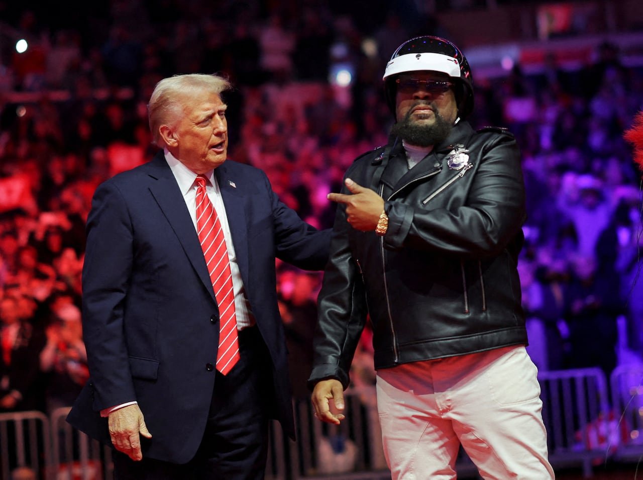 default-92 Man in a suit and red tie stands with man dressed in leather jacket and hat