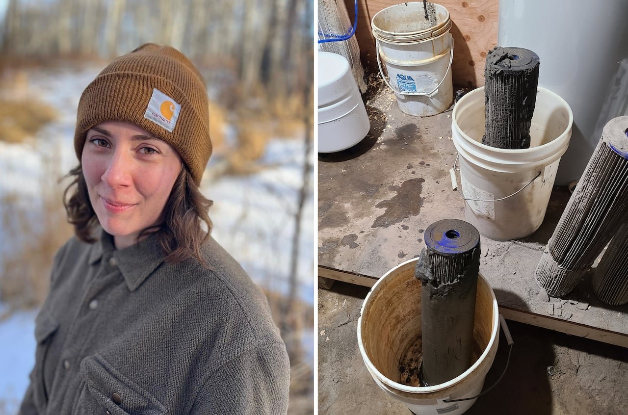 A woman in a touque and a water filter clogged with dark sand.