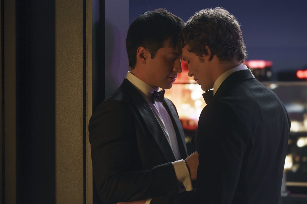 default-947 Two men in tuxedos leaning their heads together on a rooftop.