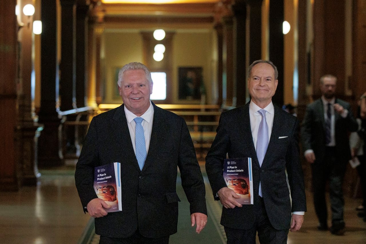 default-338 Two men walk side-by-side holding identical books.
